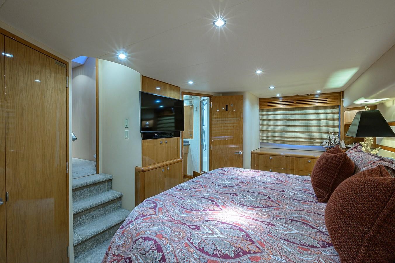a bedroom with a bed and a television aboard INSTIGATOR Yacht for Sale