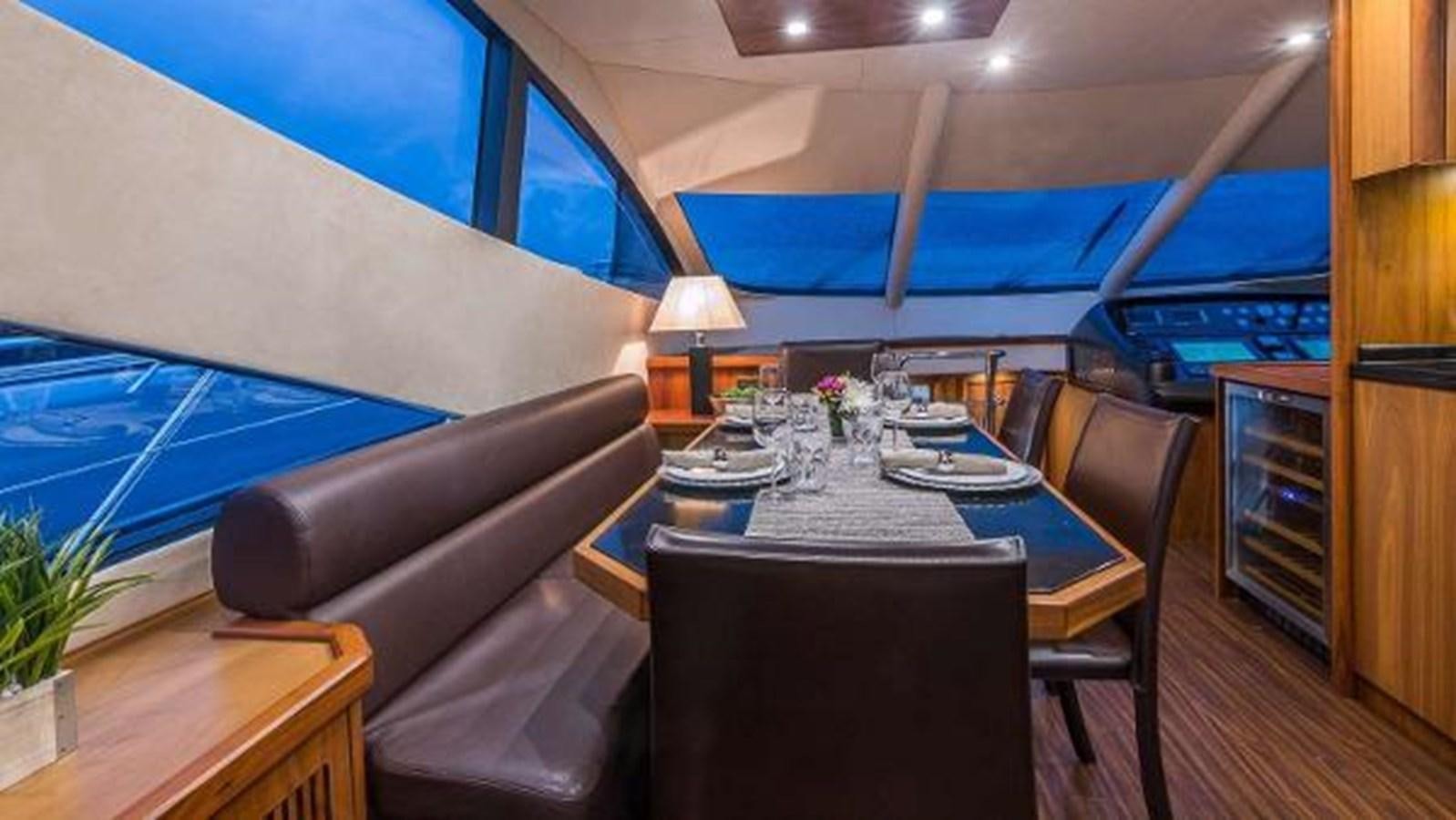 a room with a table and chairs aboard TWINS Yacht for Sale