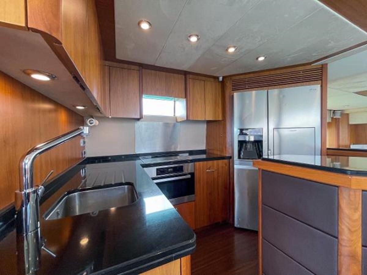 a kitchen with wooden cabinets aboard TWINS Yacht for Sale
