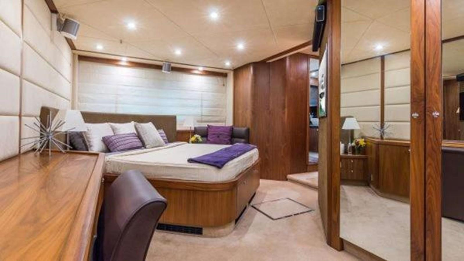 a bedroom with a bed and a chair aboard TWINS Yacht for Sale