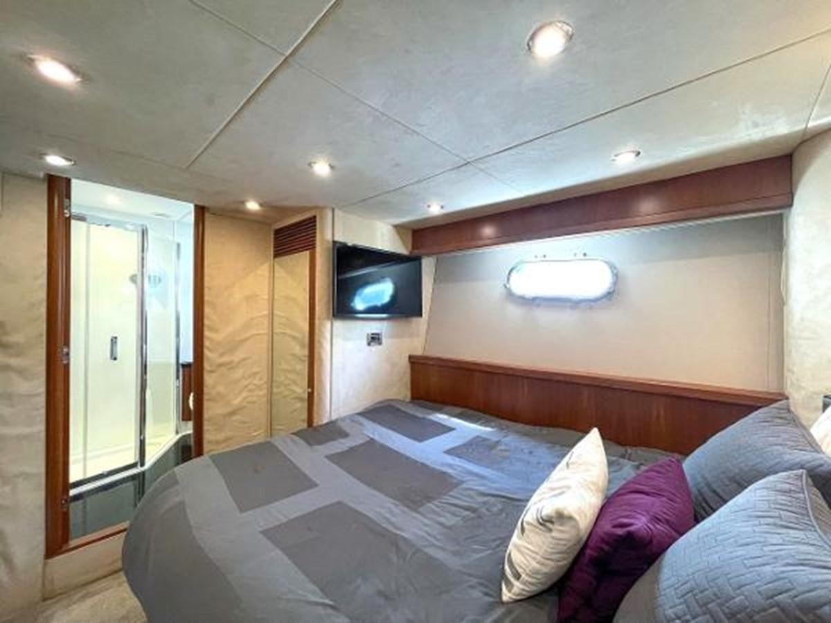 a bedroom with a bed and a tv on the wall aboard TWINS Yacht for Sale