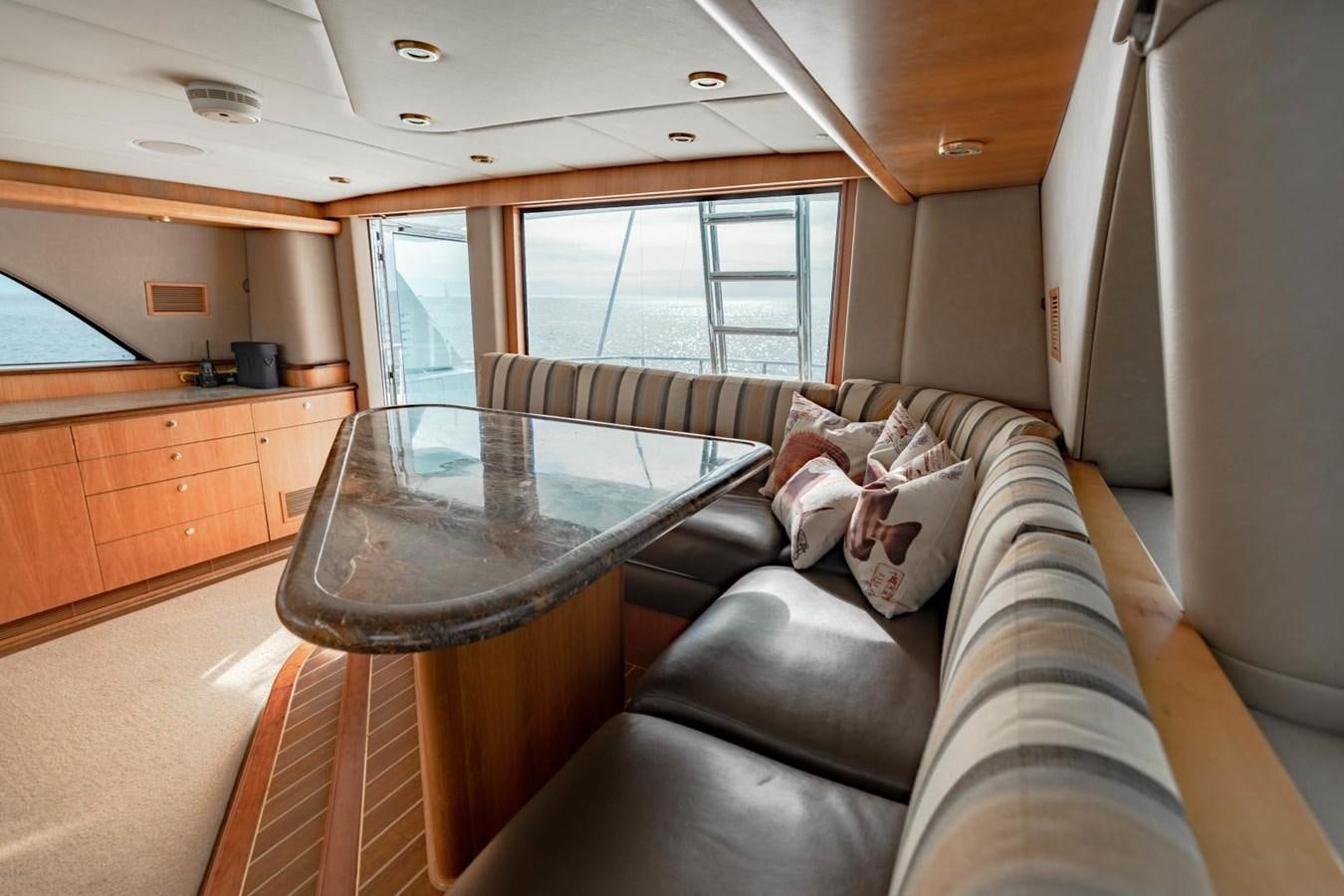 a living room with a glass table aboard PRIME TIME Yacht for Sale