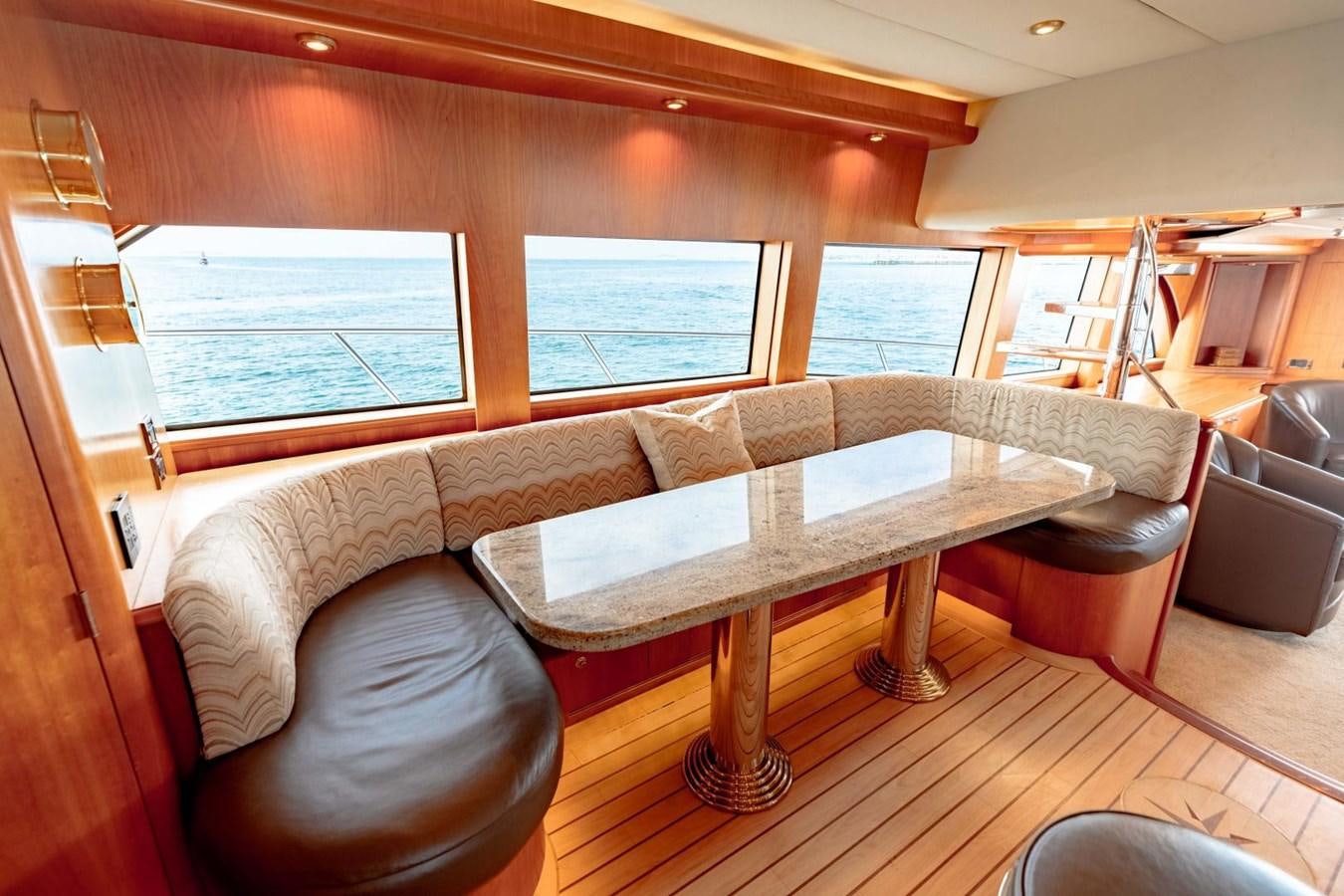 a living room with a table and couches aboard PRIME TIME Yacht for Sale