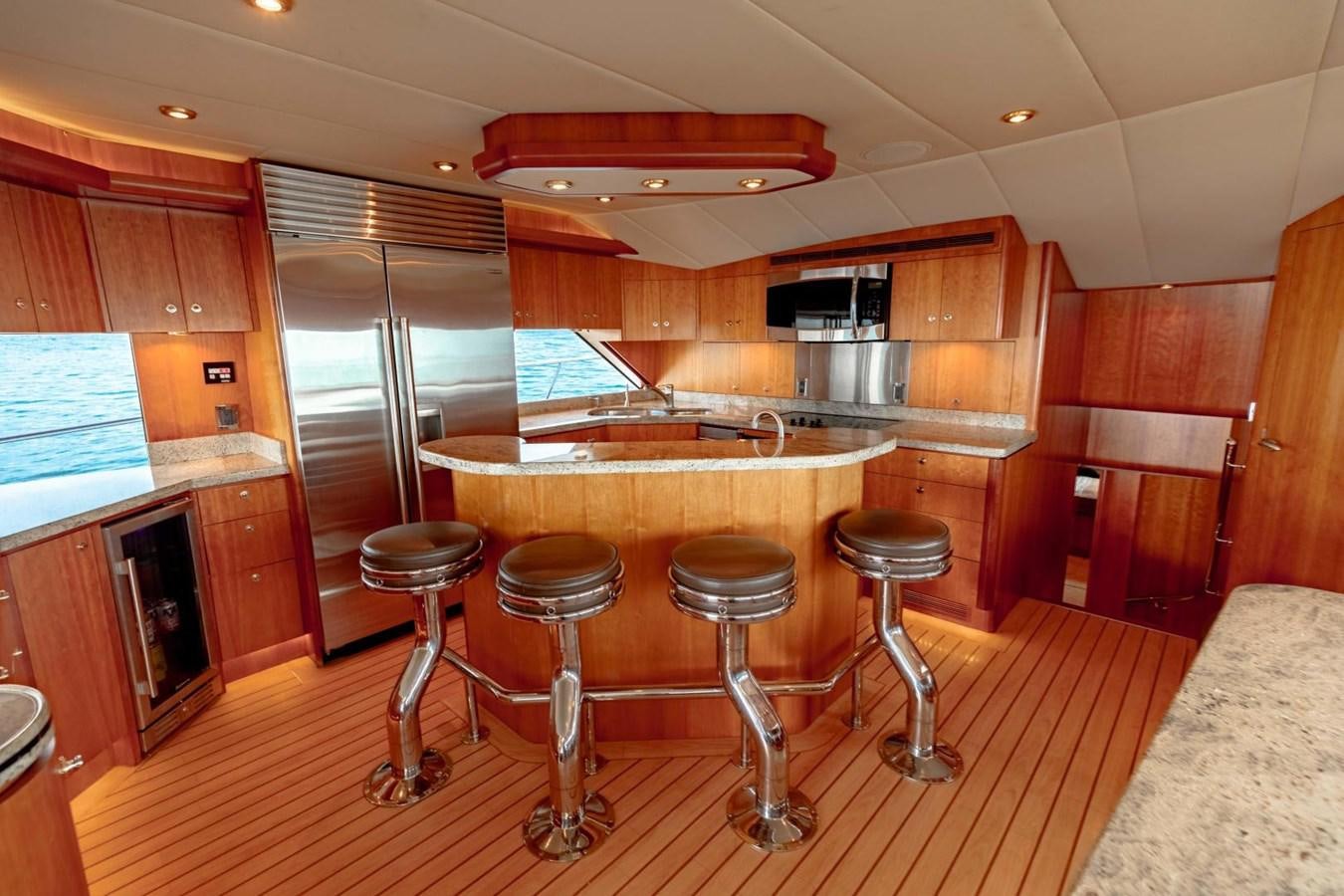 a kitchen with stools and a bar aboard PRIME TIME Yacht for Sale
