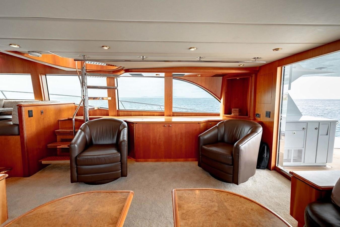 a room with a couch and a table and a large window aboard PRIME TIME Yacht for Sale