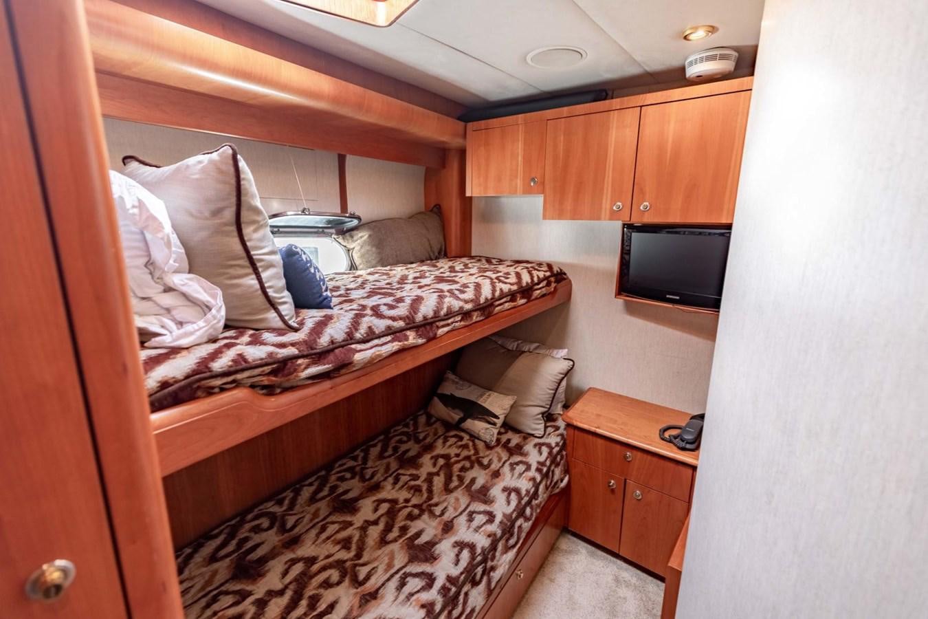 a bedroom with a bed and television aboard PRIME TIME Yacht for Sale