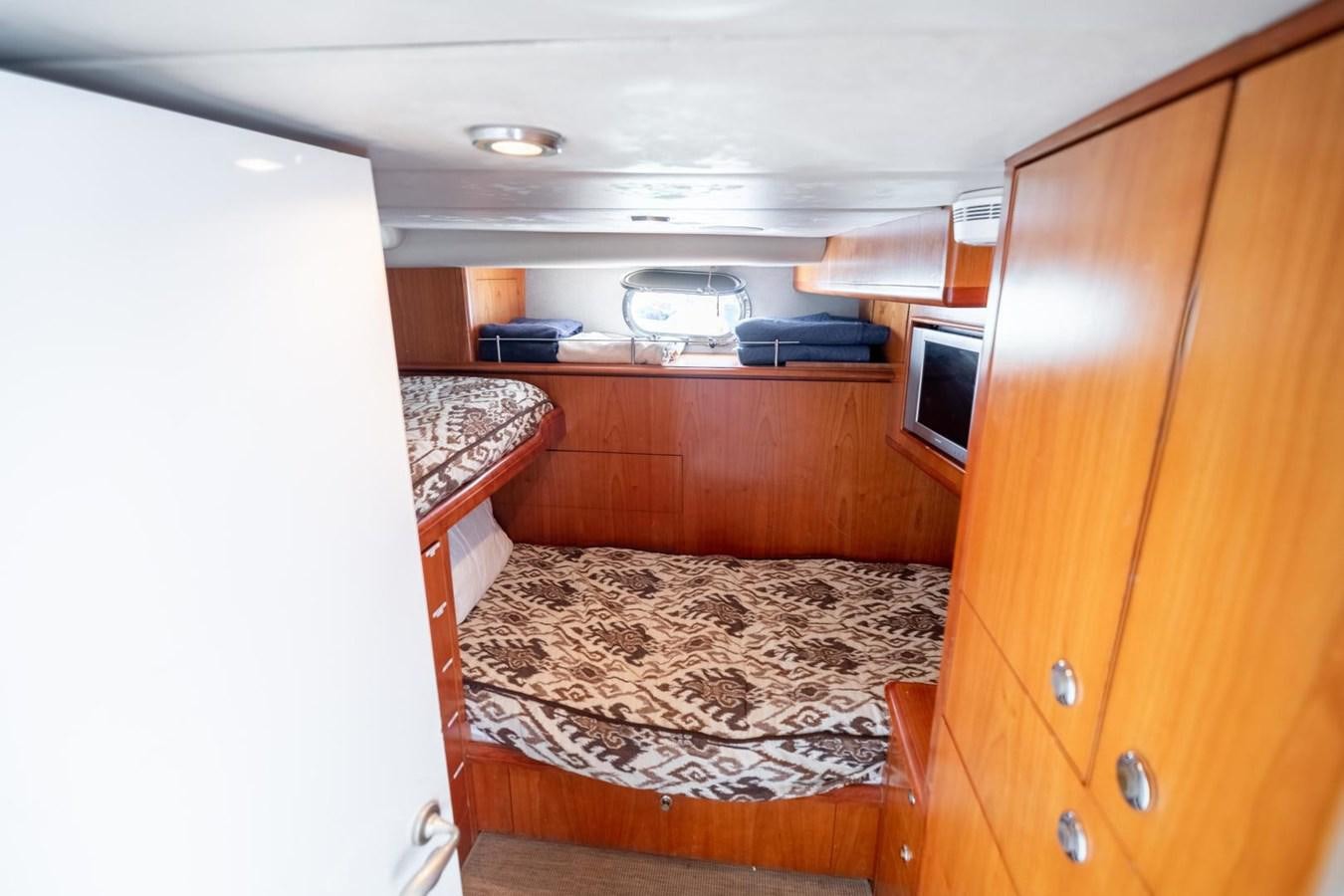 a small bedroom with a bed aboard PRIME TIME Yacht for Sale