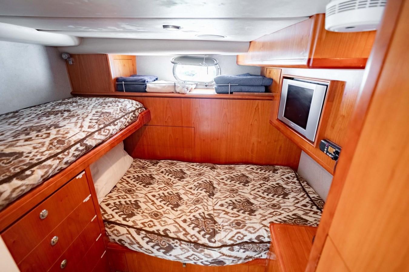 a small bedroom with a small television aboard PRIME TIME Yacht for Sale