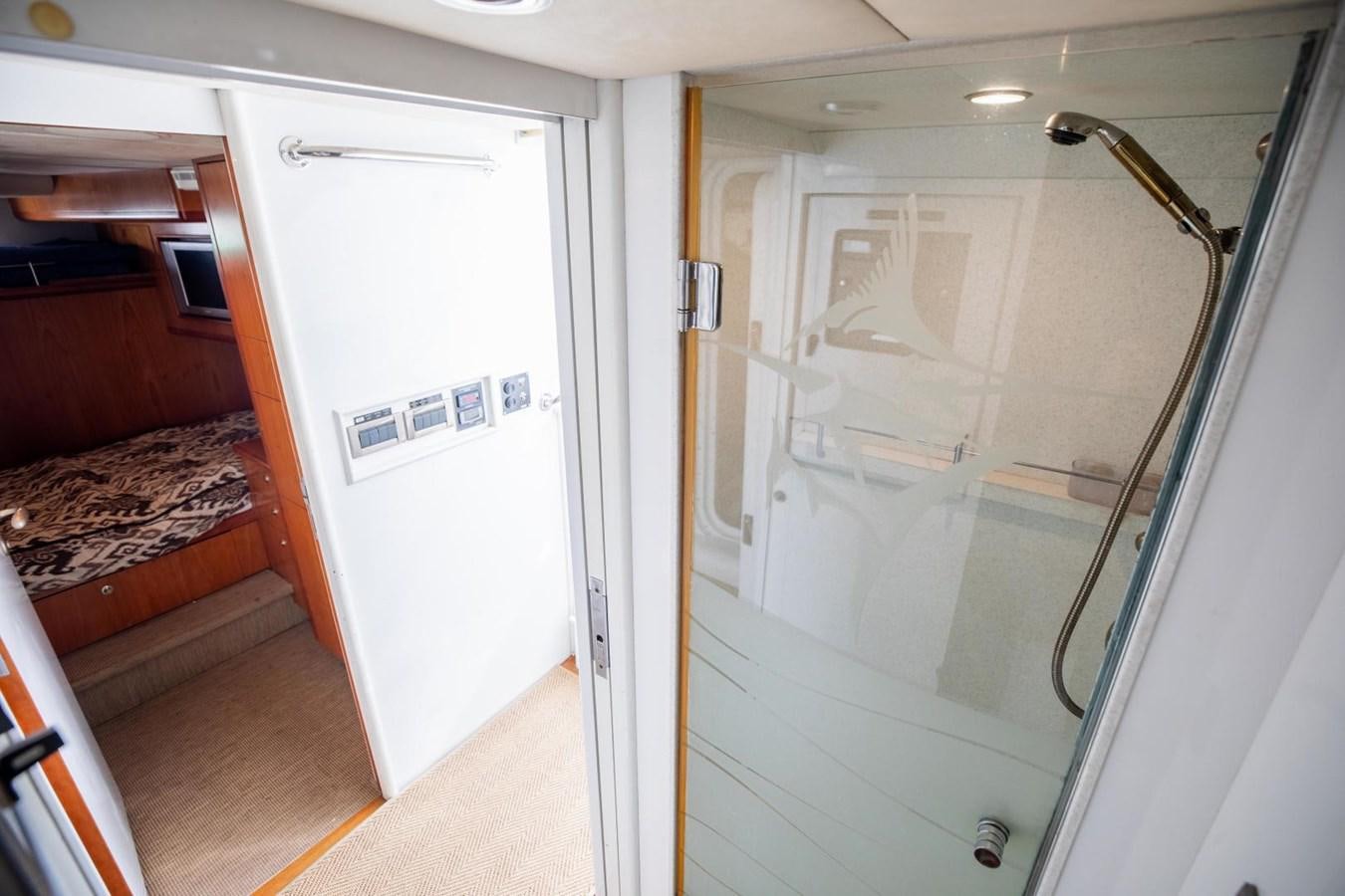 a room with a bed and a door aboard PRIME TIME Yacht for Sale