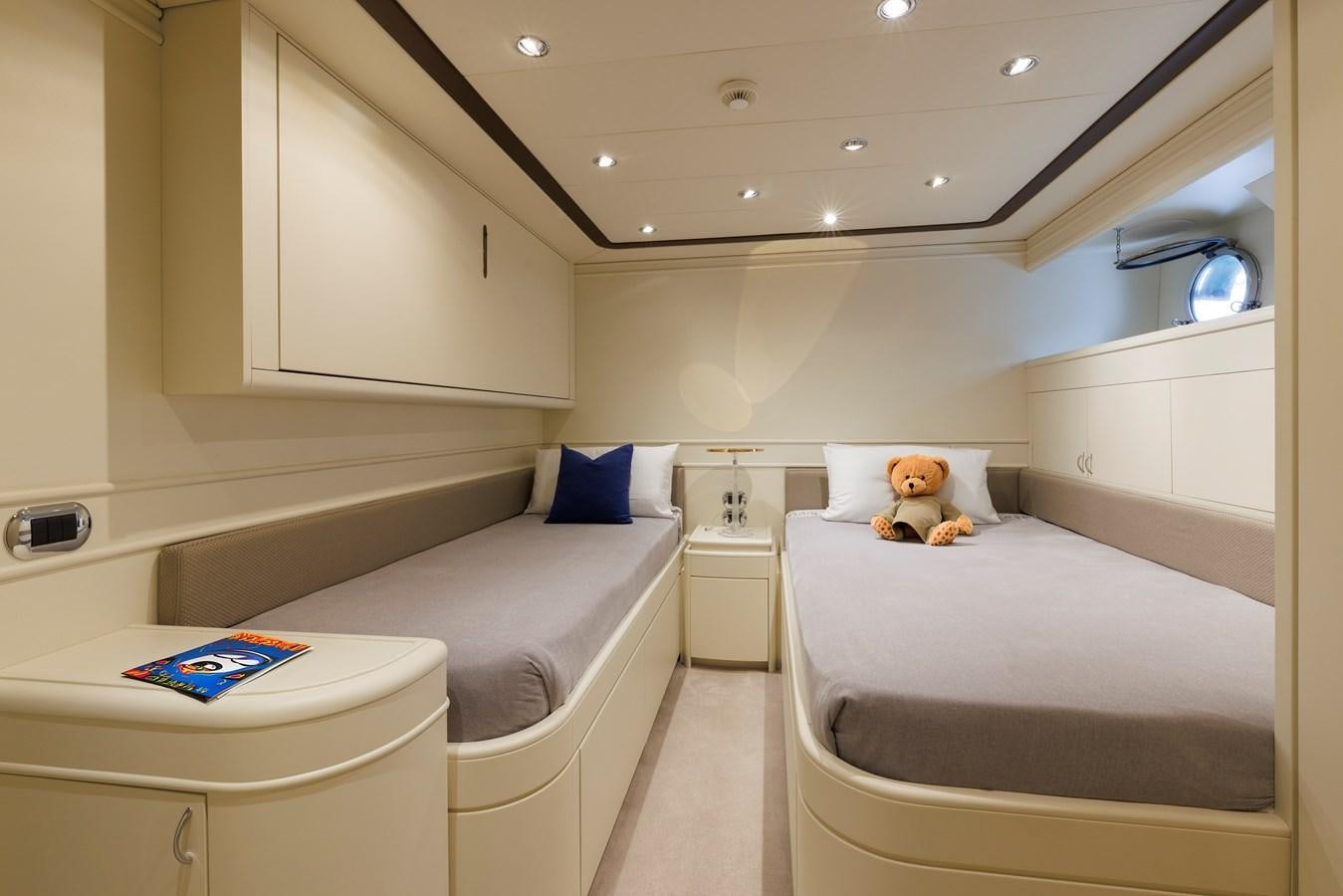 a small white bedroom with a teddy bear on the bed aboard DON CIRO Yacht for Sale