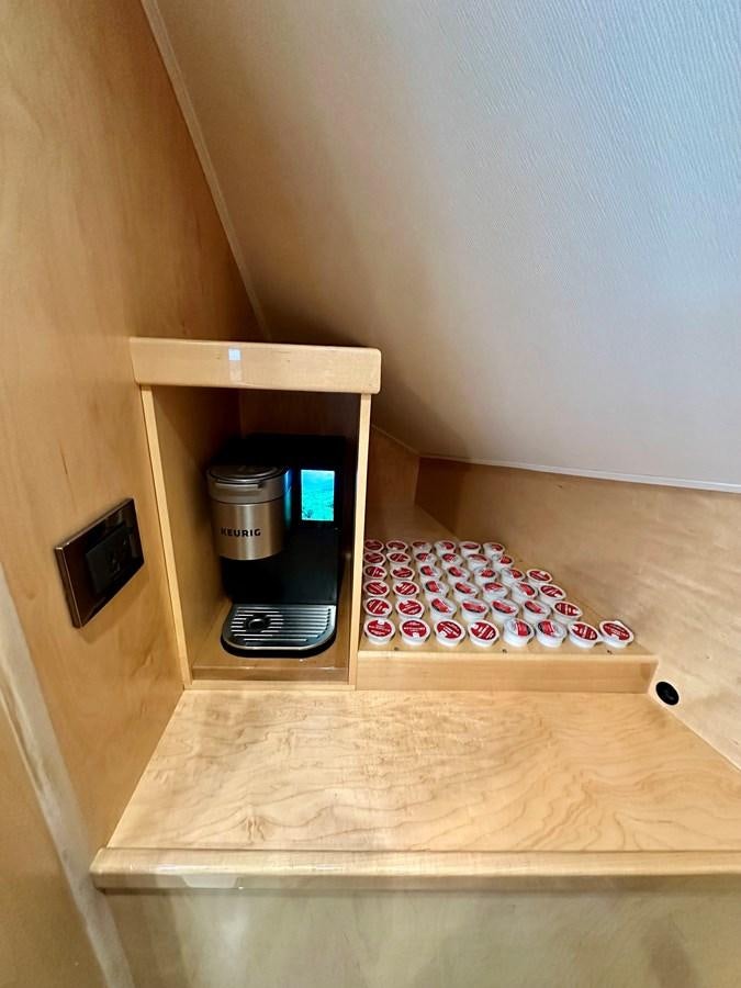 a small wood cabinet with a coffee maker on it aboard FREAK SHOW Yacht for Sale