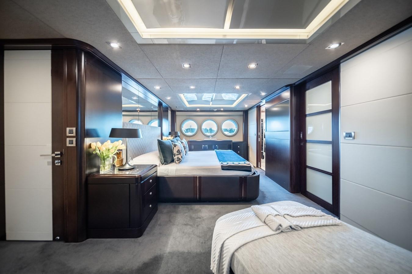 a bedroom with a bed and desk aboard QUANTUM Yacht for Sale