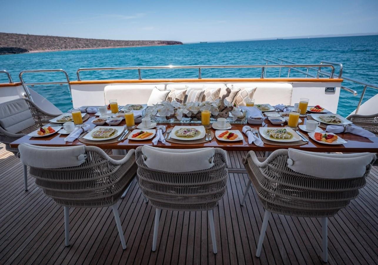 a table set for a meal on a beach aboard CANADOS FLYBRIDGE FAST Yacht for Sale