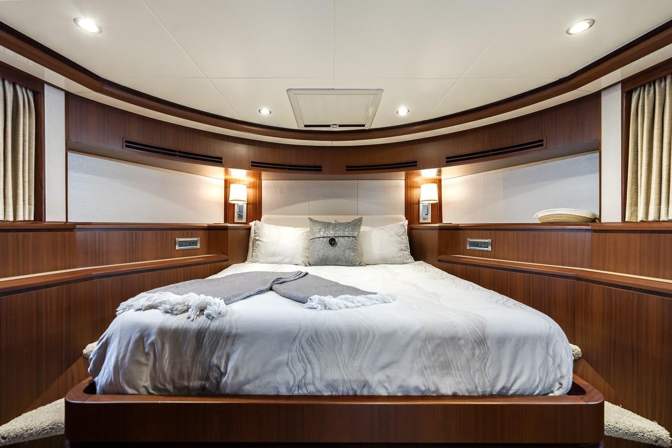 a bed with a wooden headboard aboard UNCORKED Yacht for Sale
