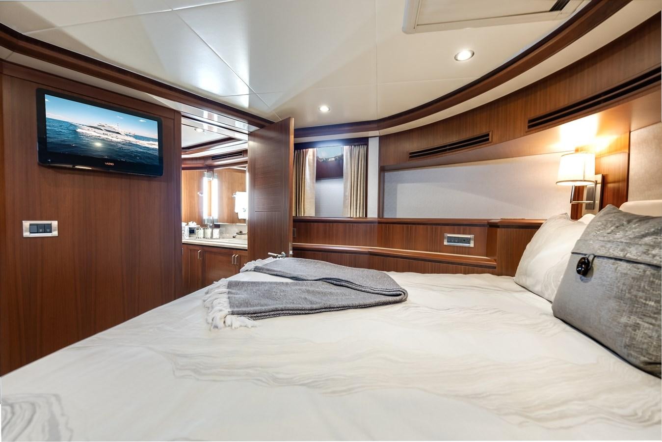 a bed with a television on the wall aboard UNCORKED Yacht for Sale