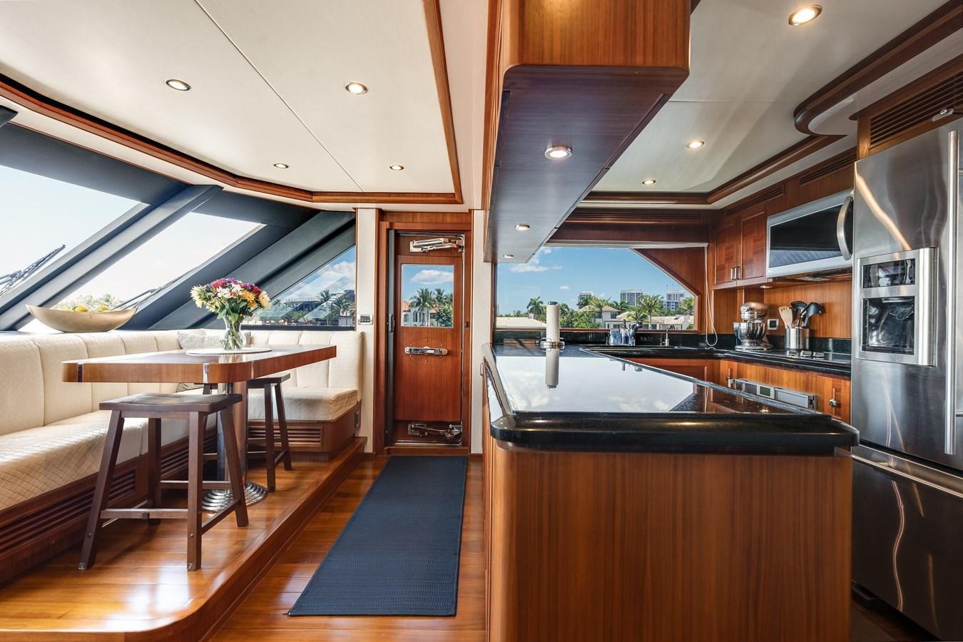 a kitchen with a table and a refrigerator aboard UNCORKED Yacht for Sale
