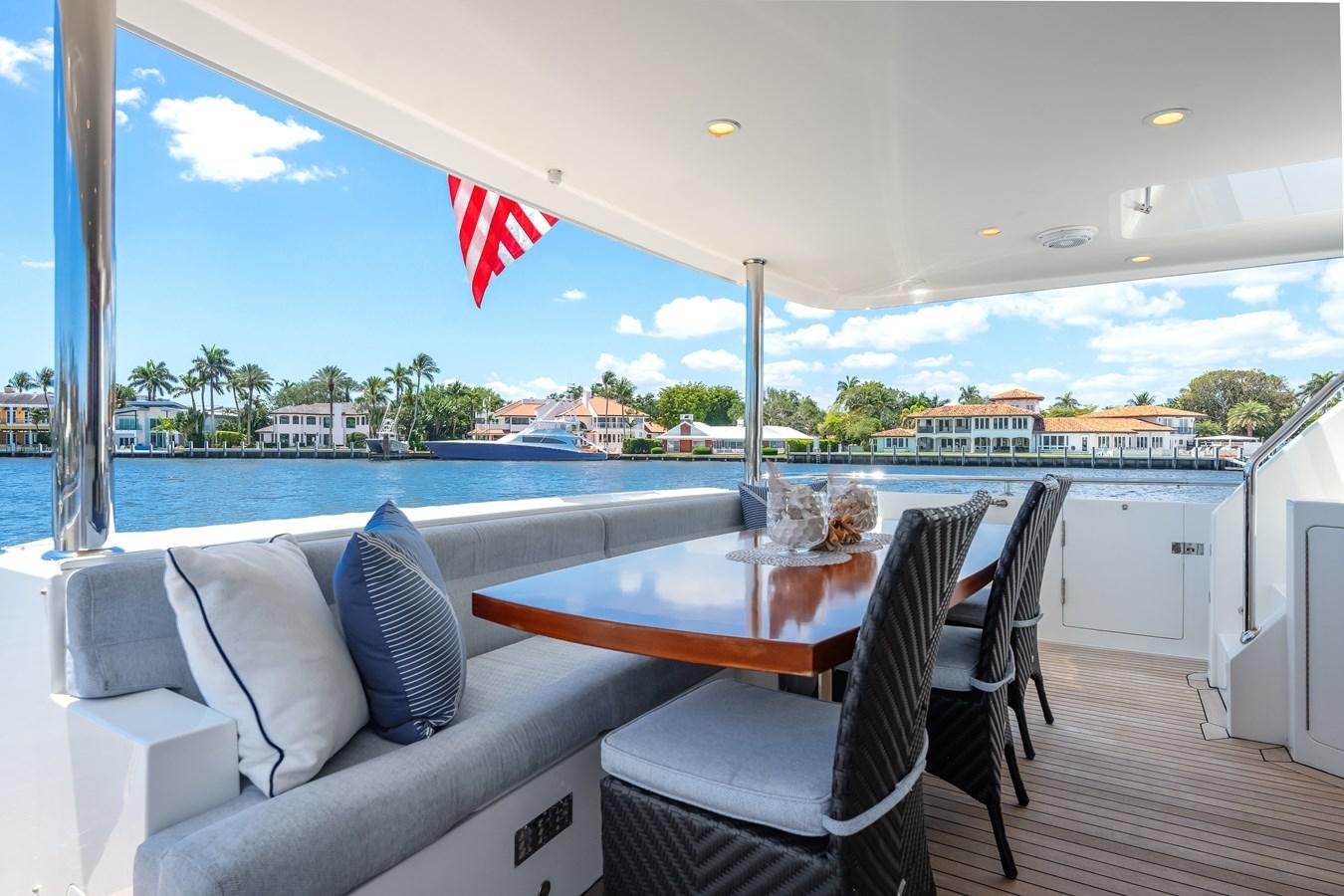 a table and chairs on a deck overlooking a body of water aboard UNCORKED Yacht for Sale