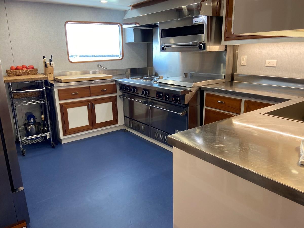 a kitchen with a stove and cabinets aboard BUCKPASSER Yacht for Sale