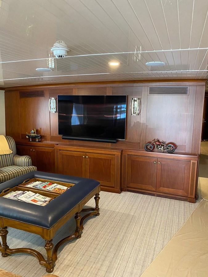 a living room with a leather couch and a television aboard BUCKPASSER Yacht for Sale