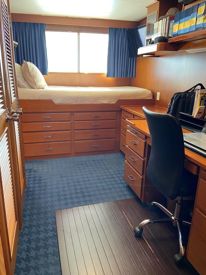 a bedroom with a desk and a bed aboard BUCKPASSER Yacht for Sale