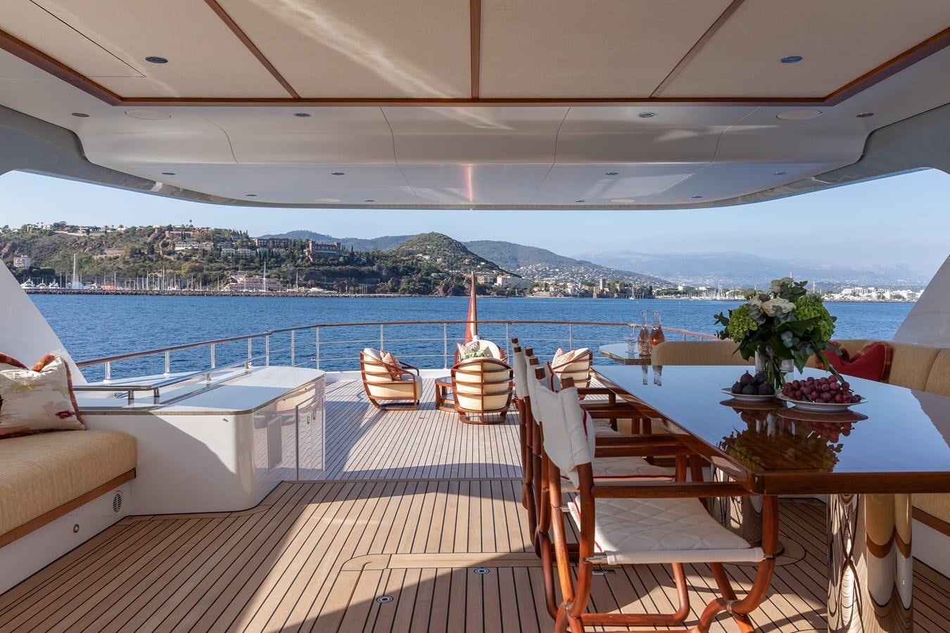 a deck with chairs and tables on it by a body of water aboard SEAFLOWER Yacht for Sale