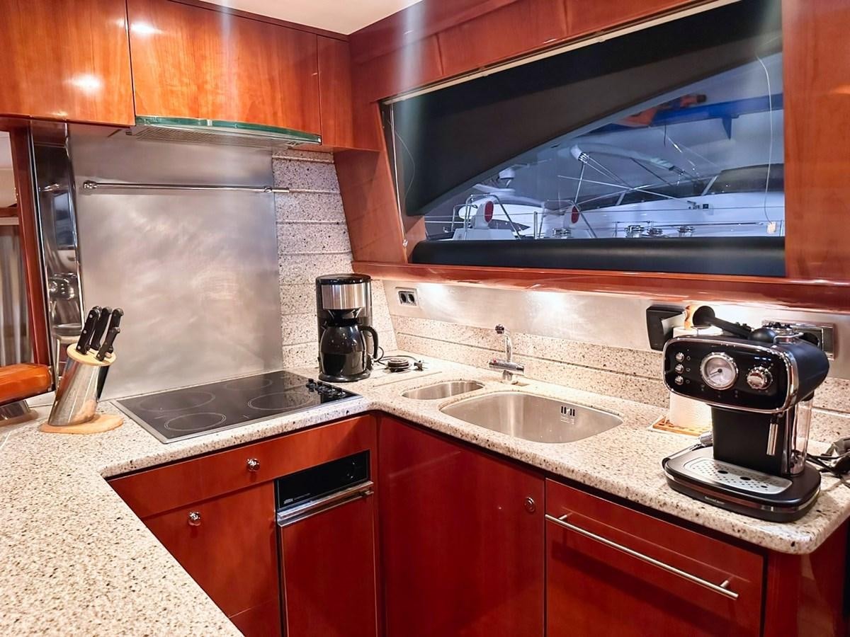 a kitchen with a tv and a sink aboard WET ASSET Yacht for Sale