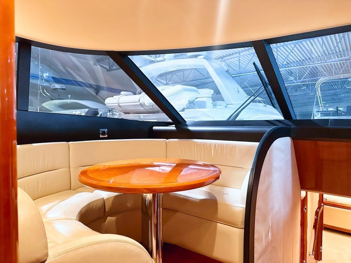 a table and a chair in a room with a window aboard WET ASSET Yacht for Sale