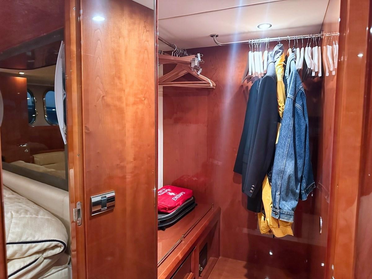 a closet with clothes on the wall aboard WET ASSET Yacht for Sale