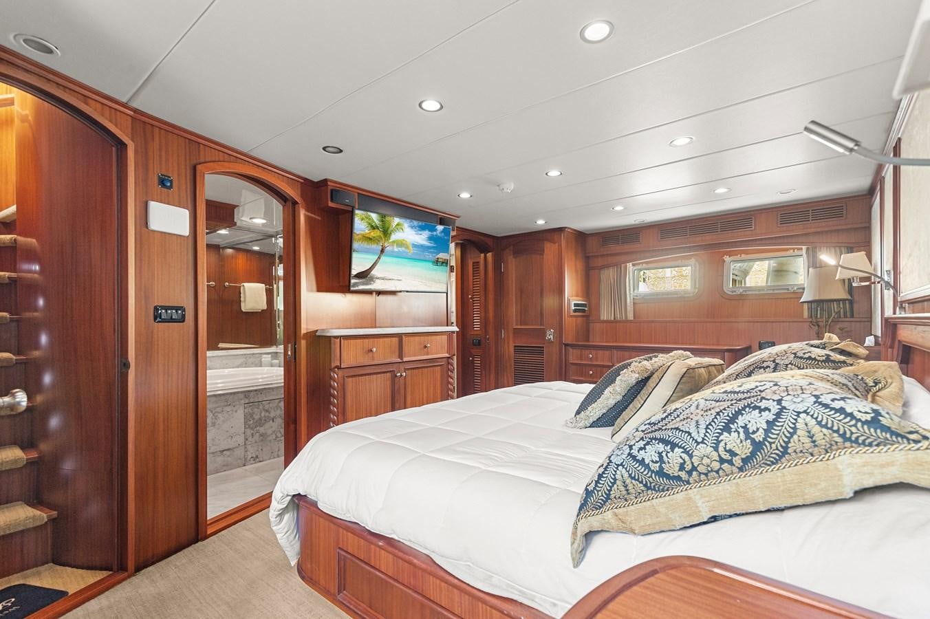 a bedroom with a bed and a wood closet aboard SEAS TO SEE Yacht for Sale