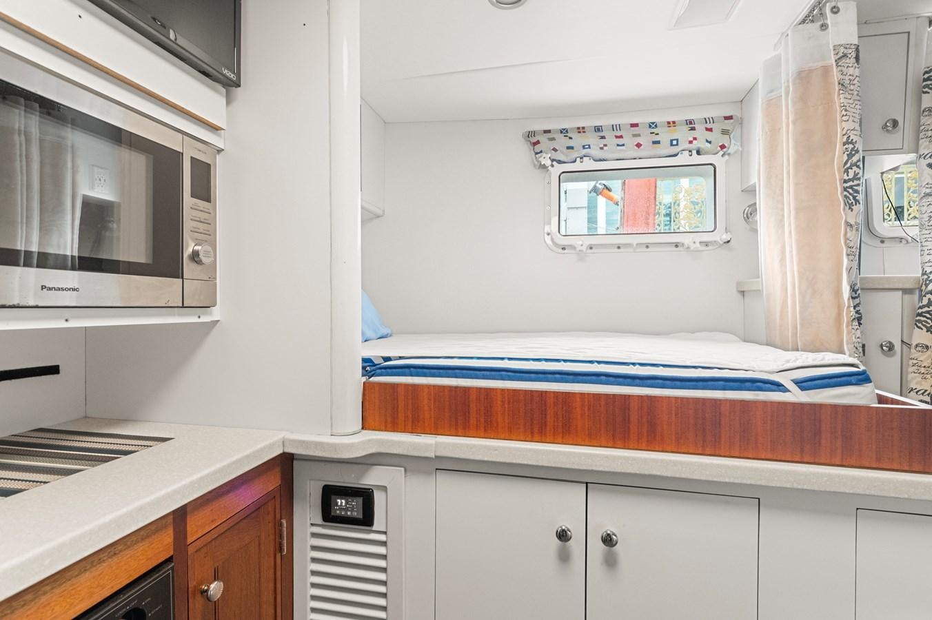 a bedroom with a bed and a microwave aboard SEAS TO SEE Yacht for Sale