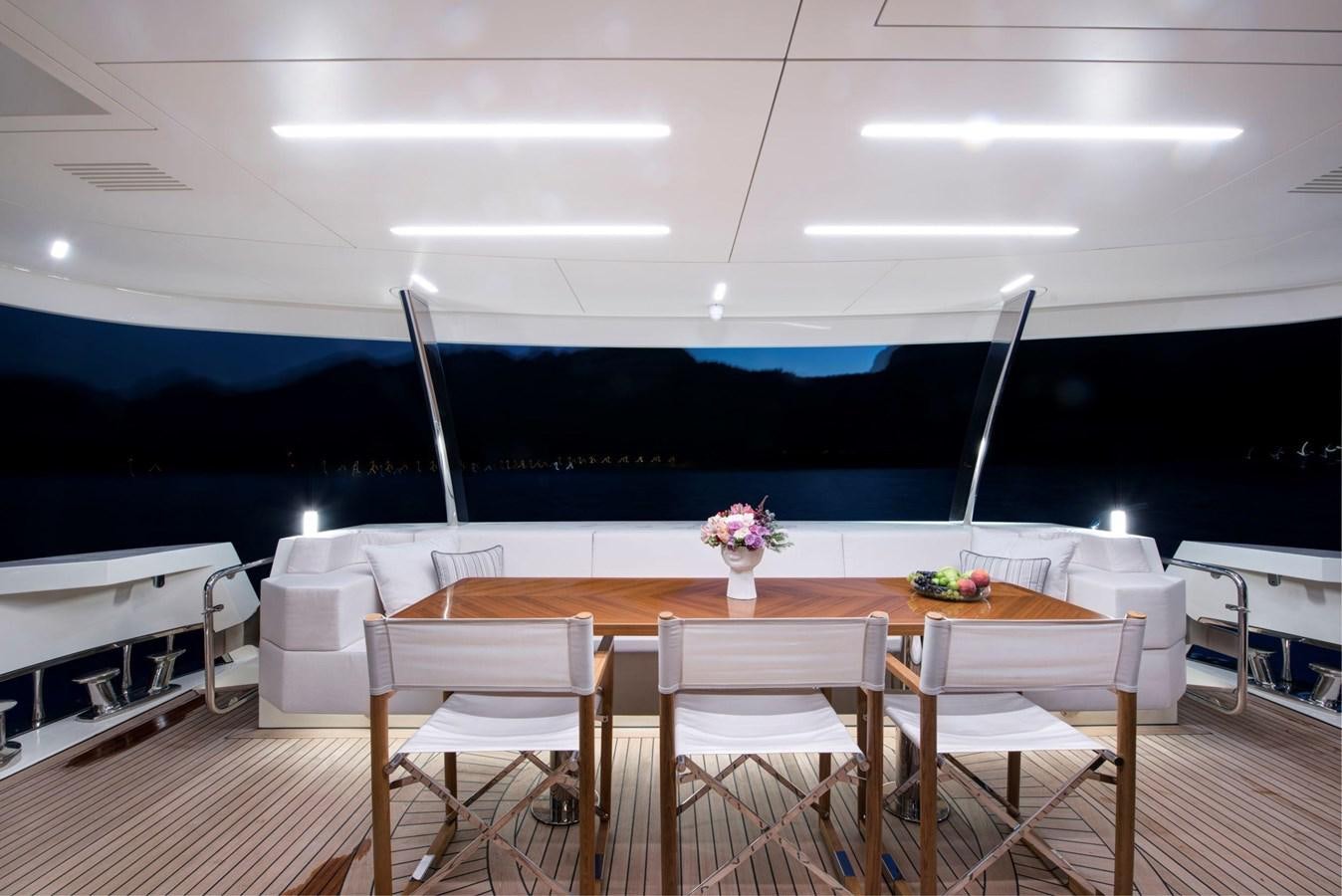 a table with chairs and a large blue wall in the background aboard SANDRO Yacht for Sale