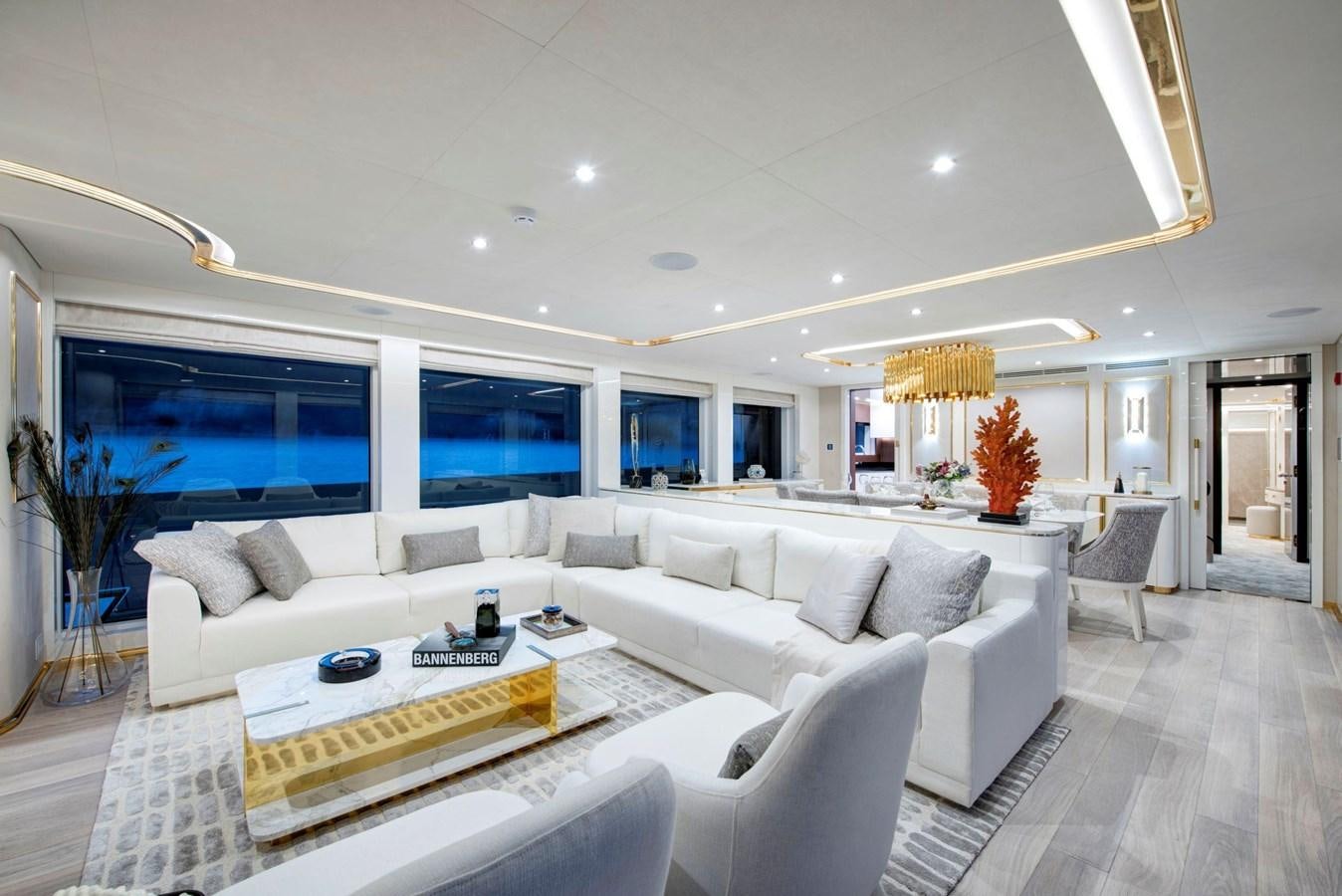 a living room with a large white sofa and a large window aboard SANDRO Yacht for Sale