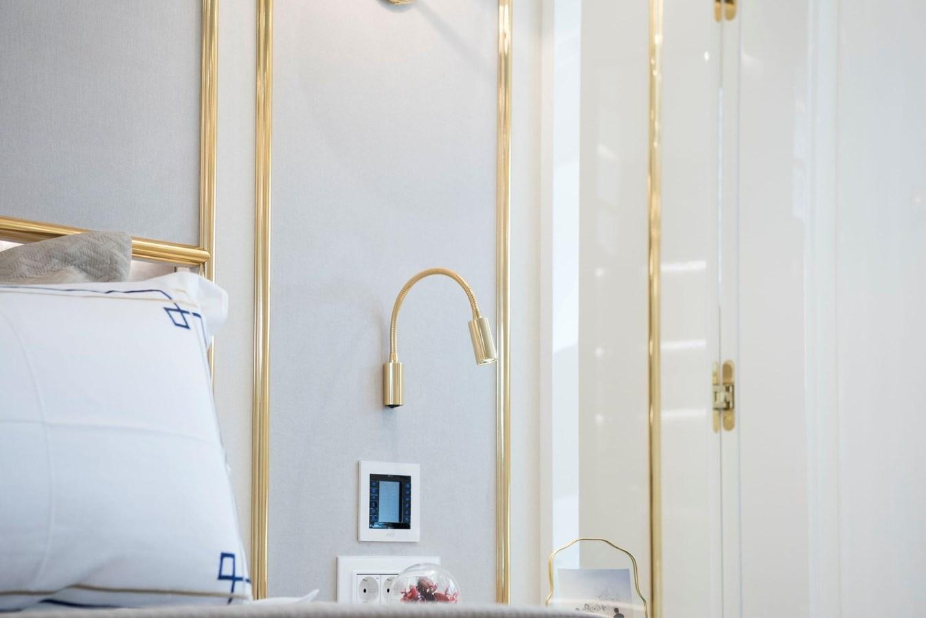 a white bed with a lamp on it aboard SANDRO Yacht for Sale