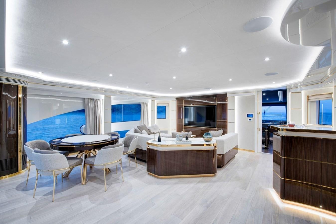 a large living room with a table and chairs aboard SANDRO Yacht for Sale