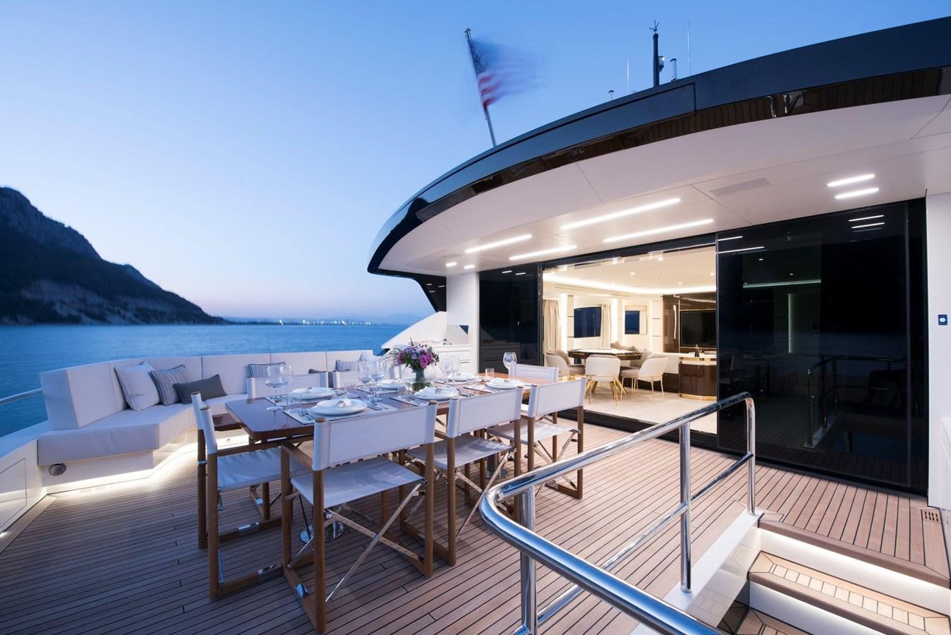 a deck with a table and chairs on it aboard SANDRO Yacht for Sale