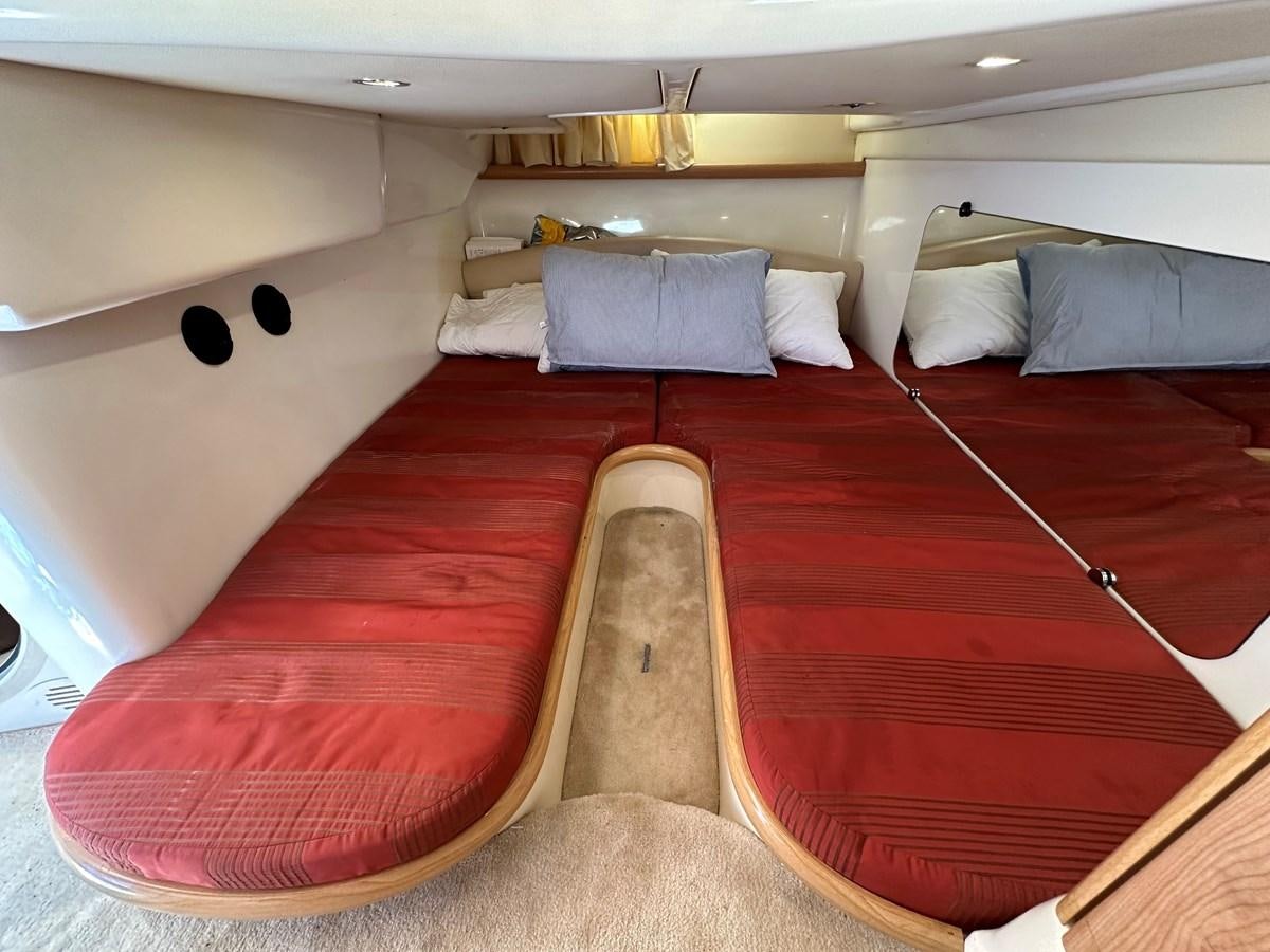 a room with a bed and a couple of seats aboard 2009 ATLANTIS 315 Yacht for Sale