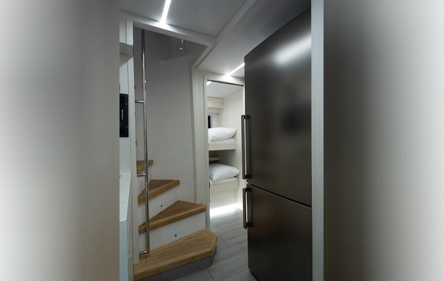 a room with a bed and a refrigerator aboard OKEAN 80/01 Yacht for Sale