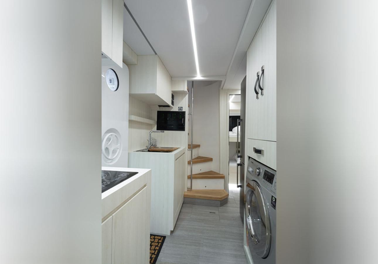a small kitchen with white cabinets aboard OKEAN 80/01 Yacht for Sale