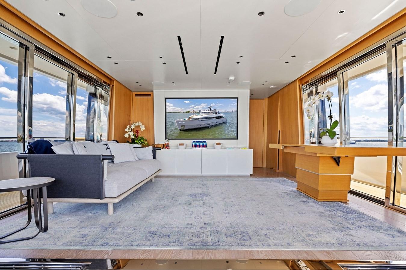 a large room with a couch and a tv aboard DON'T TELL MOM Yacht for Sale