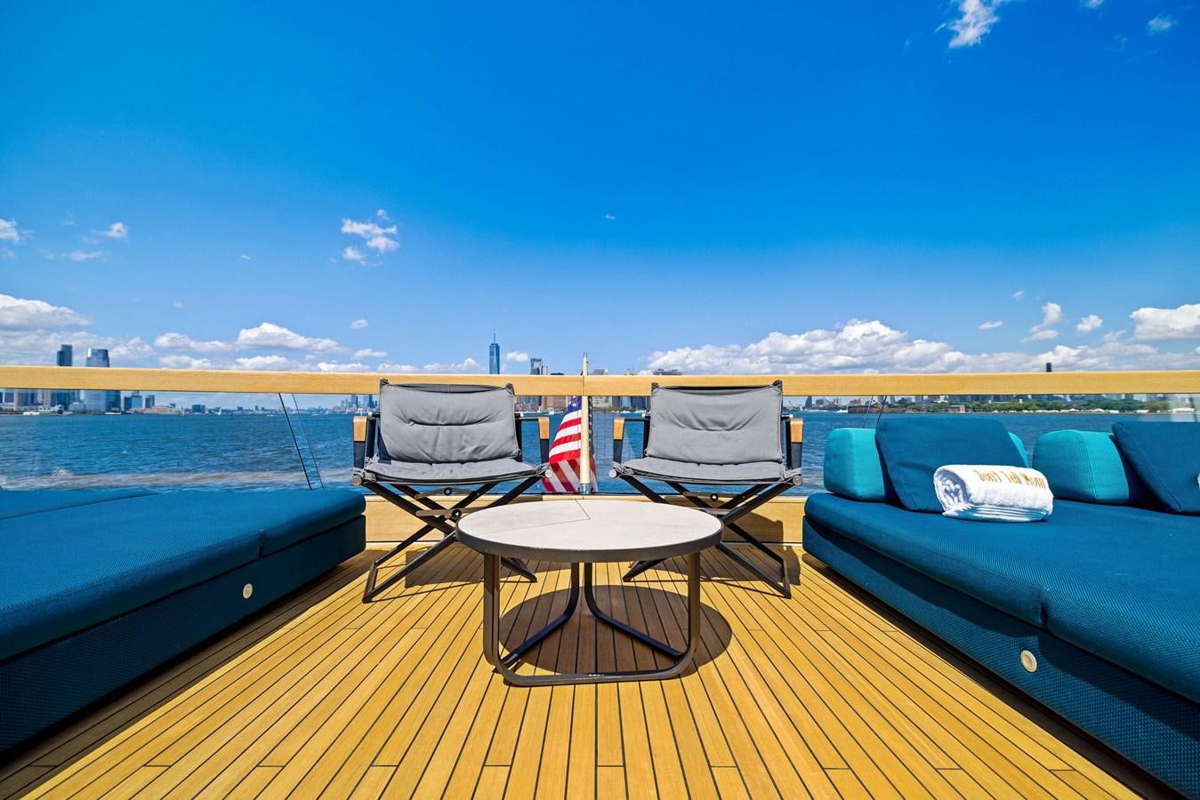a couple of chairs on a deck overlooking a body of water aboard DON'T TELL MOM Yacht for Sale