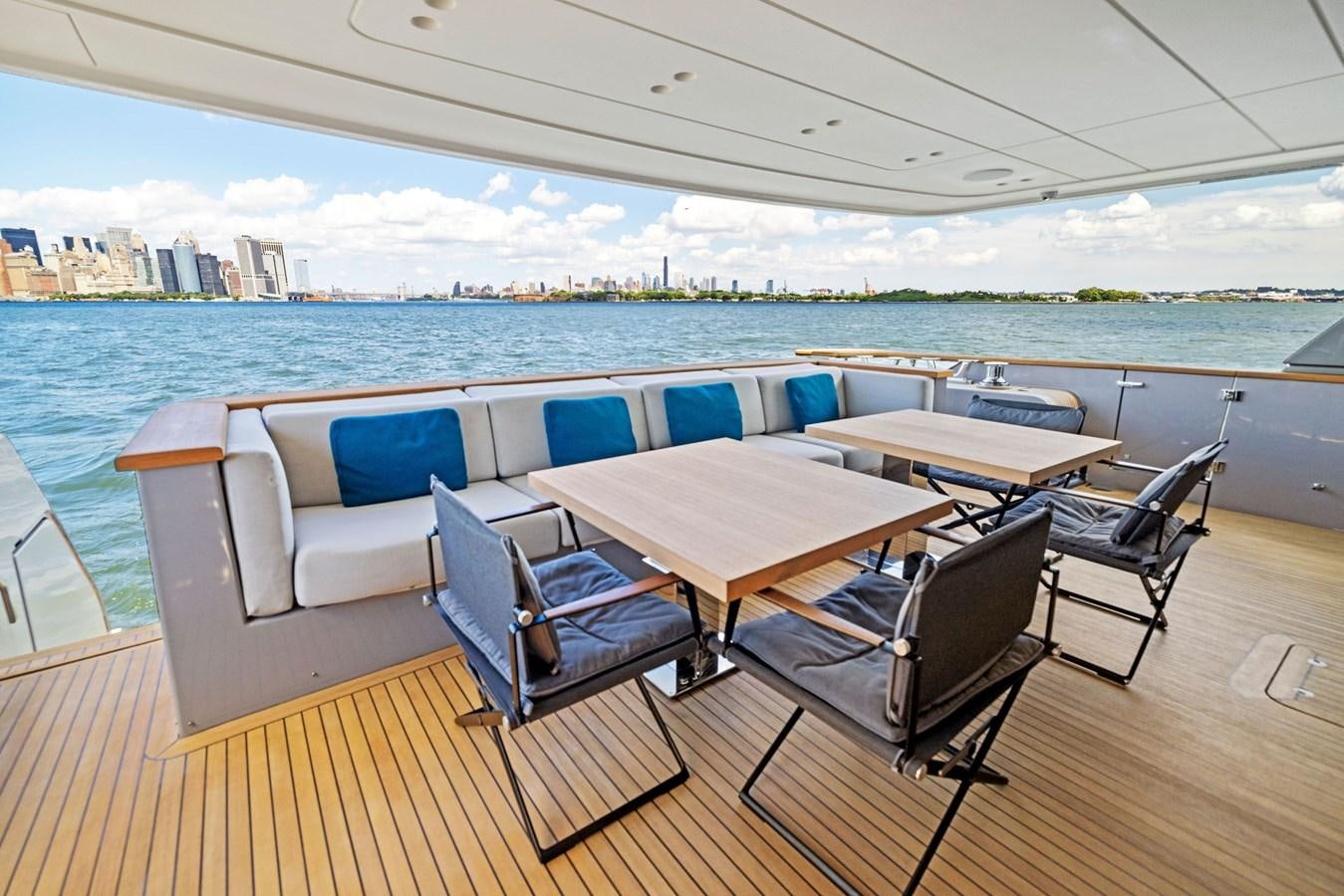 a table and chairs on a deck overlooking a body of water aboard DON'T TELL MOM Yacht for Sale