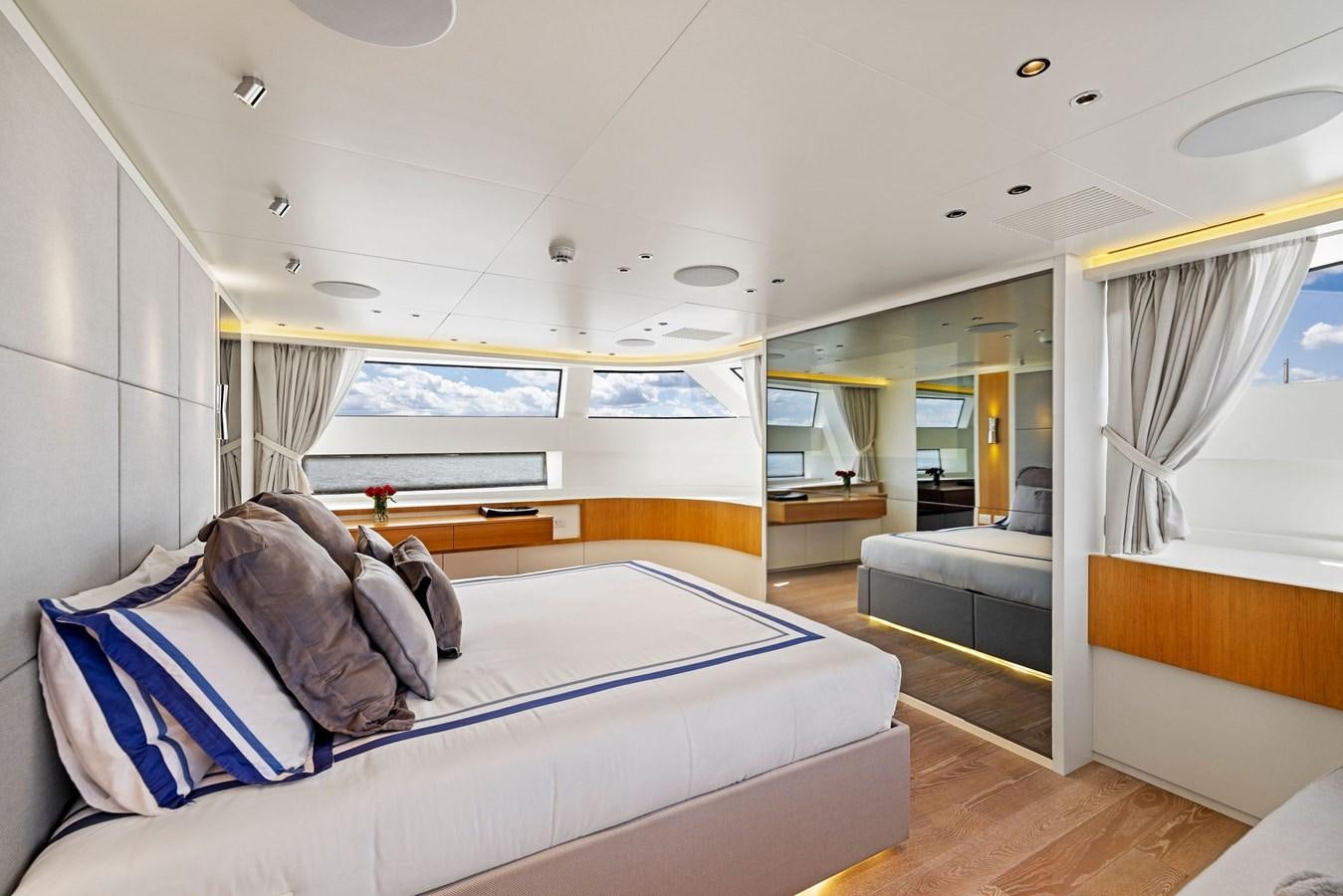 a bedroom with a bed and a window aboard DON'T TELL MOM Yacht for Sale