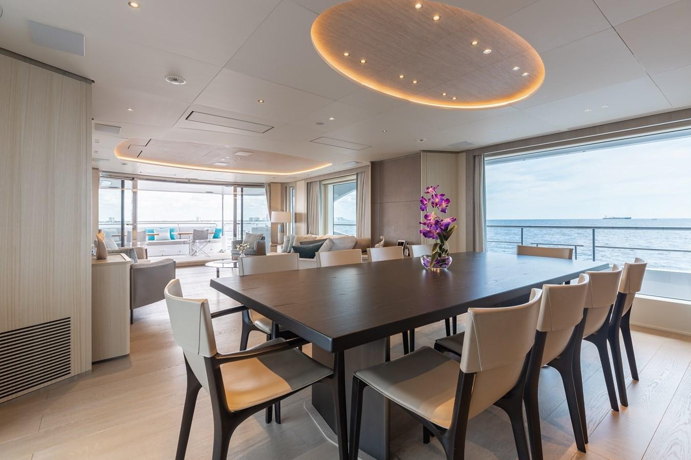 a large dining table in a large room with a large window aboard ABBENTURES III Yacht for Sale