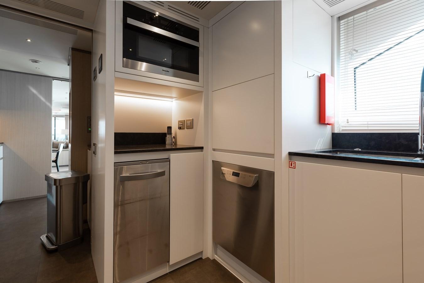 a kitchen with white cabinets aboard ABBENTURES III Yacht for Sale