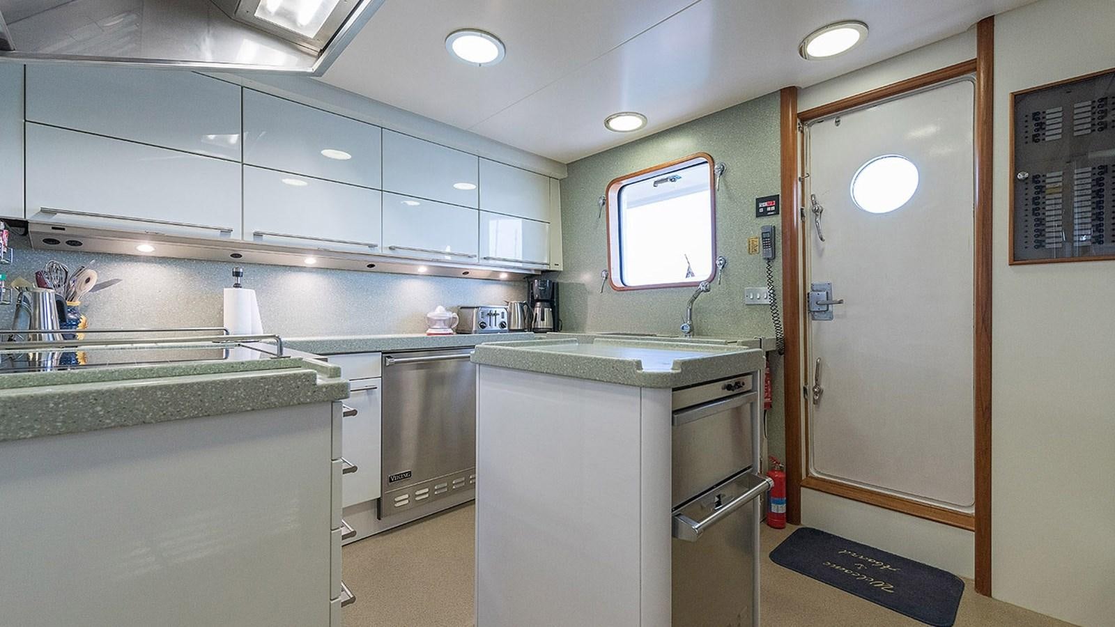a kitchen with a fridge and a microwave aboard LA REINA DEL MAR Yacht for Sale