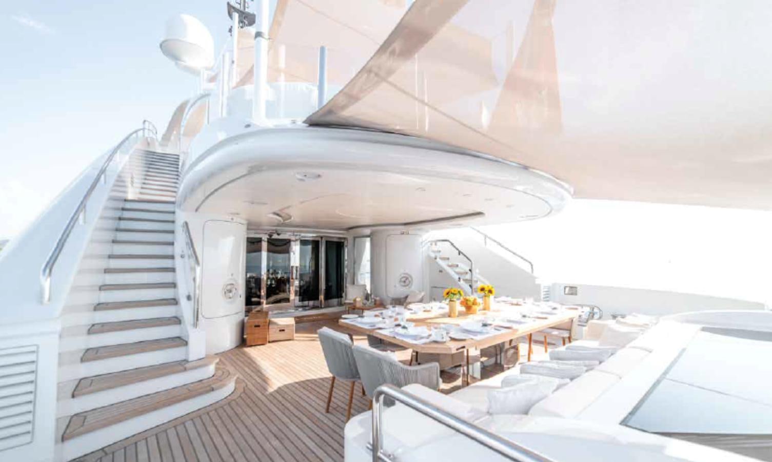 a large white building with a table and chairs aboard ALI BABA Yacht for Sale