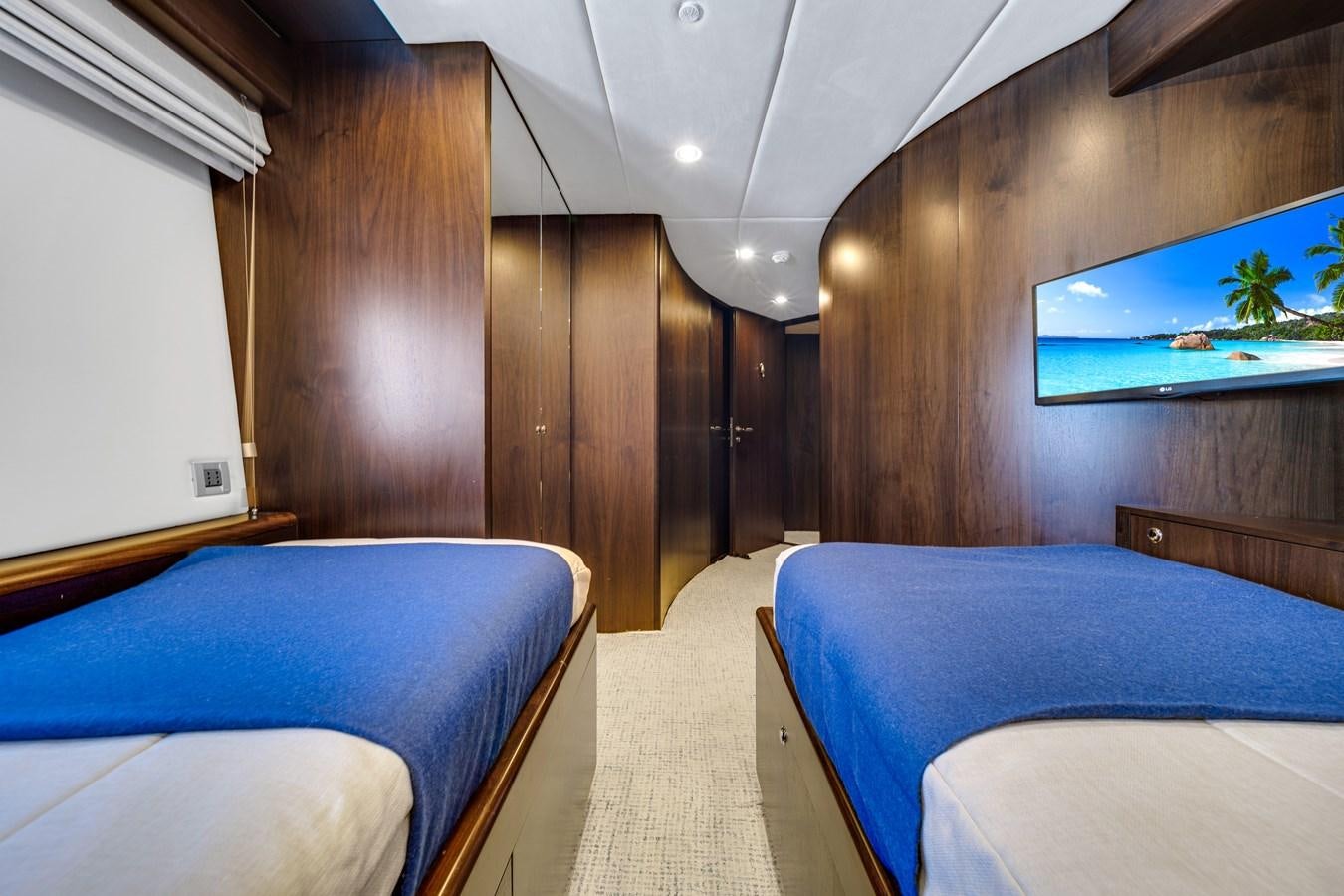 a room with wooden walls and a blue bed aboard MOONEN ROYAL DENSHIP 120 Yacht for Sale
