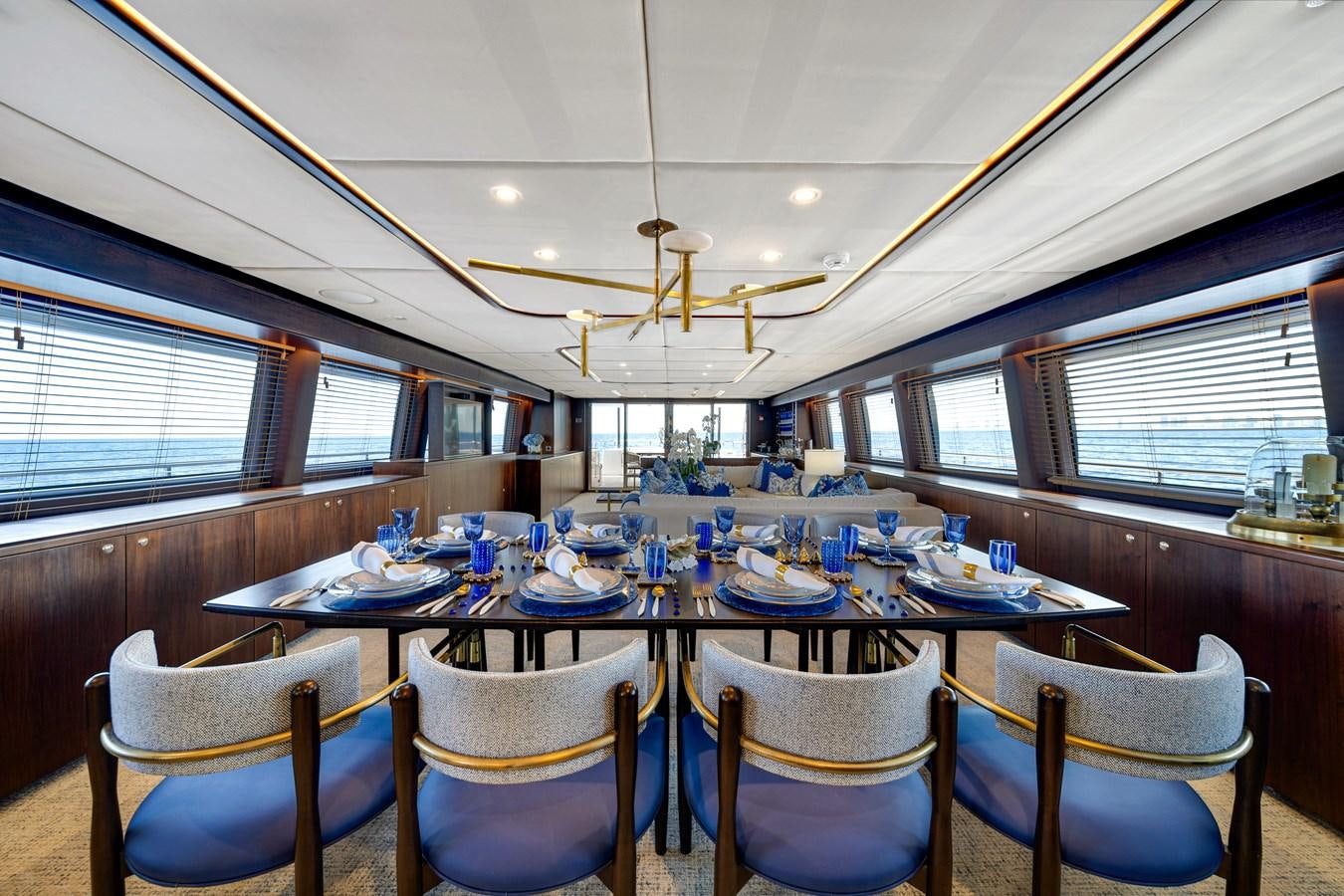 a large dining room with blue chairs aboard MOONEN ROYAL DENSHIP 120 Yacht for Sale