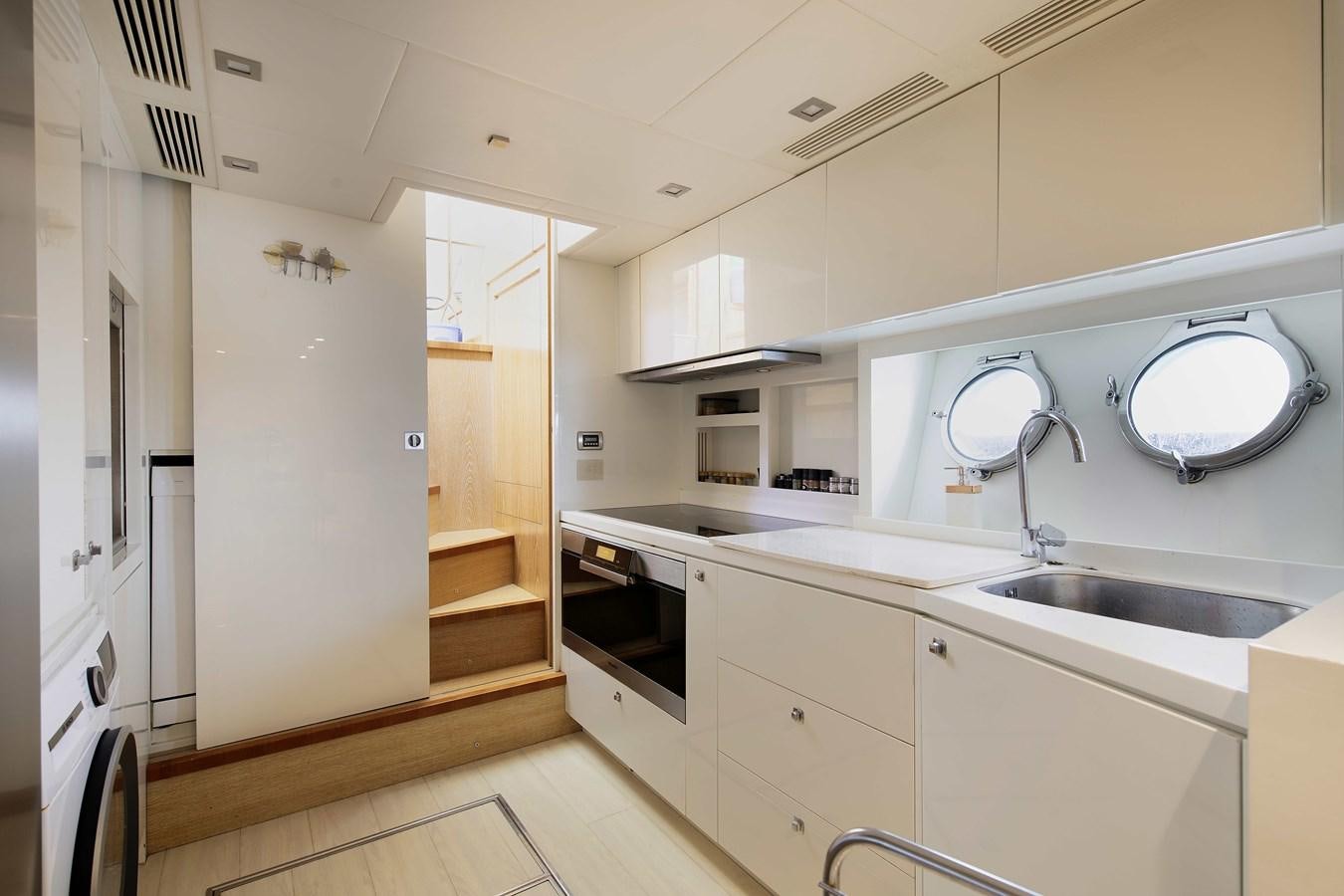 a kitchen with white cabinets aboard ANDIAMO Yacht for Sale