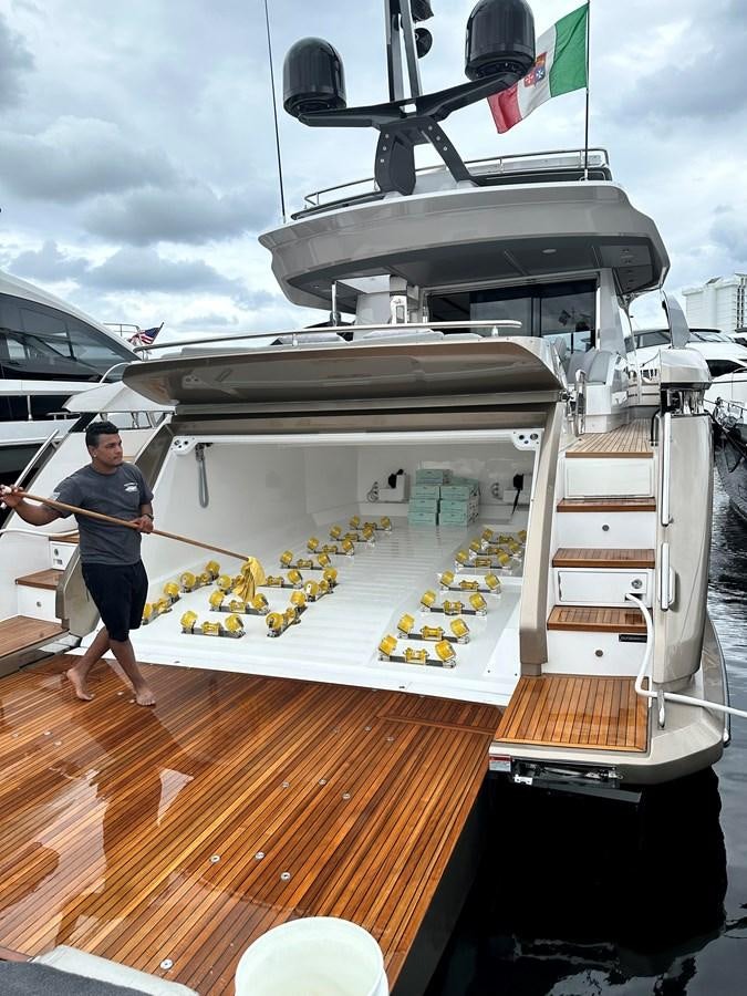 a person standing next to a large white boat on a wooden deck aboard SUNSET 8 Yacht for Sale